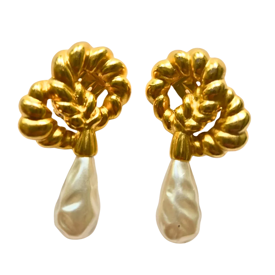 A pair of gold and pearl drop earrings with textured, scalloped gold tops and teardrop-shaped white pearls hanging below, shown on a plain white background.
