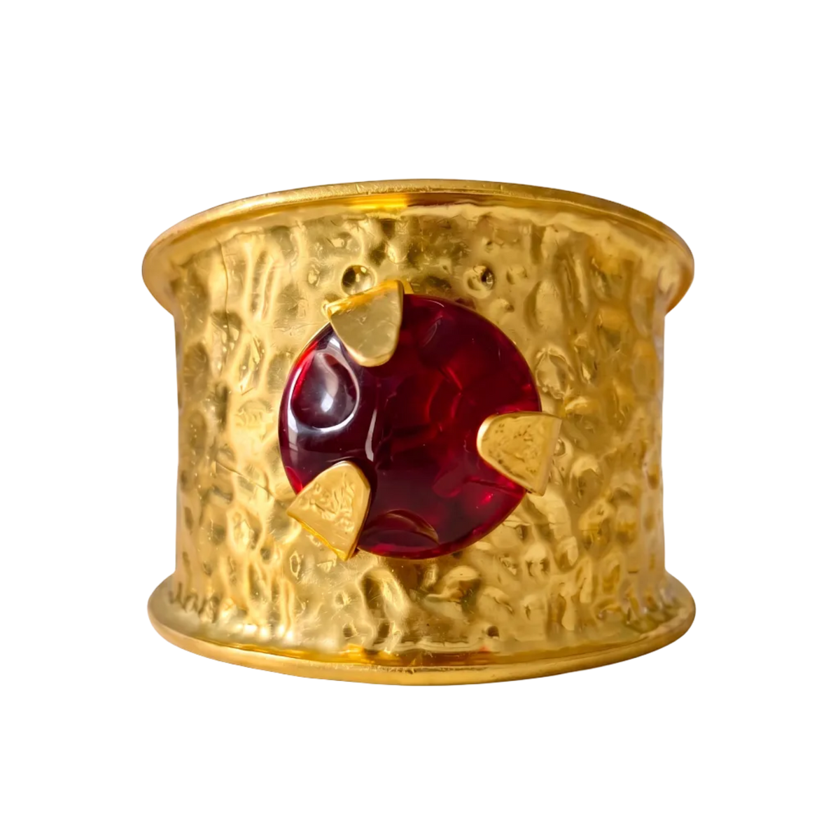 A hammered gold cuff bracelet featuring a central circular red gemstone accented by three small gold heart-shaped inlays, shown on a clean white background.