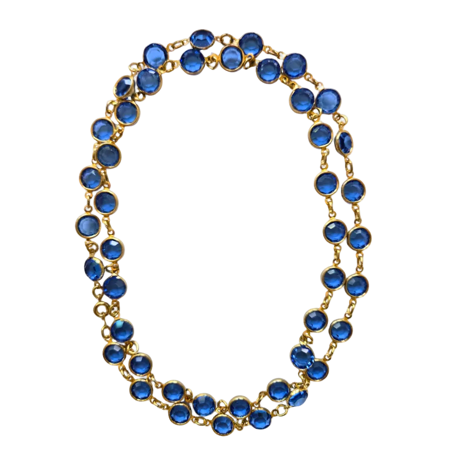 A gold-tone chain necklace featuring multiple rows of round, faceted blue gemstones, displayed on a clean white background.