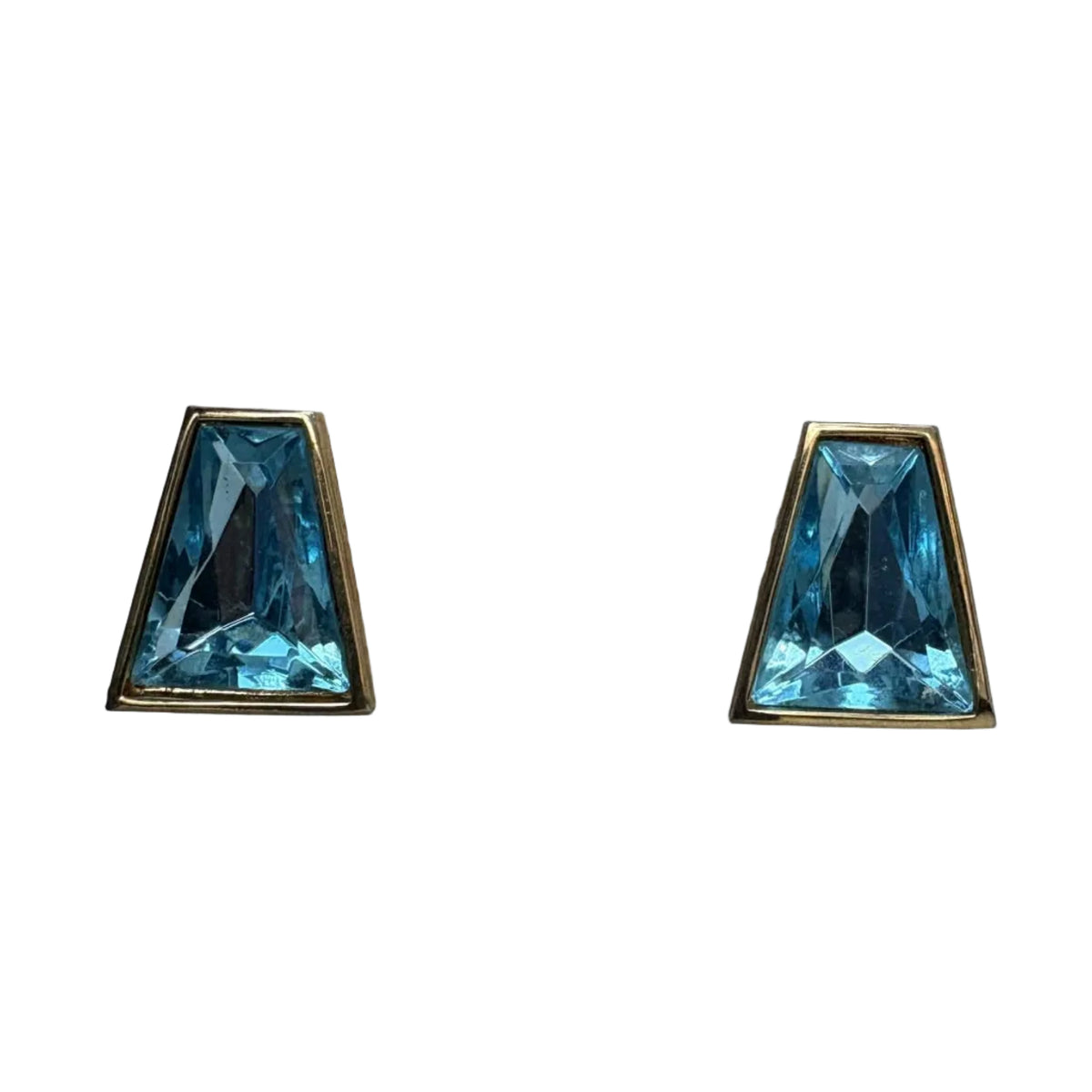 A pair of geometric stud earrings featuring faceted light blue gemstones in a trapezoid shape, set in a gold-tone metal bezel, shown against a plain white background.