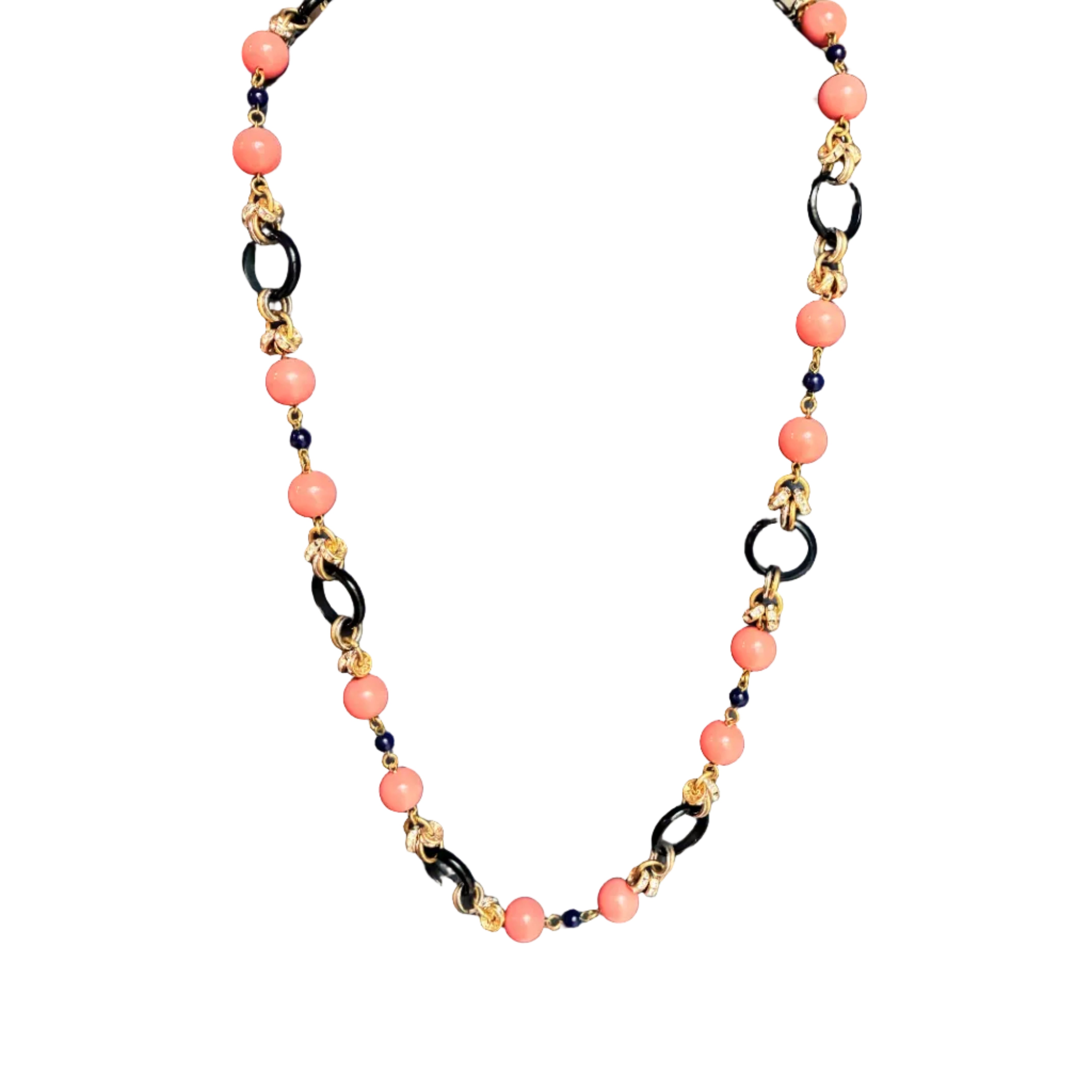 Beaded necklace features alternating coral-pink round beads, black links, and gold-toned spacer beads with gold accents