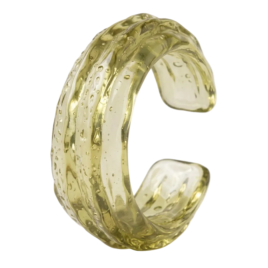 A textured, organic-shaped cuff bracelet made of translucent olive-green glass, shown on a clean white background.