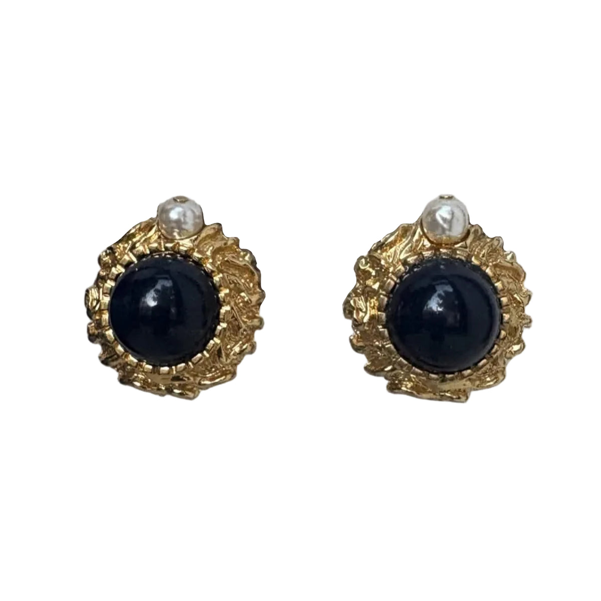 A pair of gold-toned stud earrings featuring a large round black cabochon stone in the center, accented by a small white pearl at the top, set against a plain white background.
