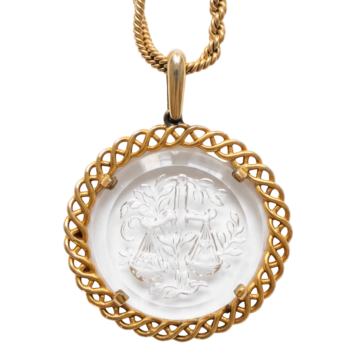 A gold pendant necklace featuring a circular clear glass medallion with an embossed scale of justice design, surrounded by a twisted gold border, on a white background.